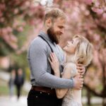 beautiful-newlyweds-are-hugging-and-smiling-against-the-blooming-pink-cherry-blossom-on-a-sunny-day.jpg