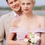 happy-just-married-couple-with-wedding-bouquet-looking-at-camera.jpg
